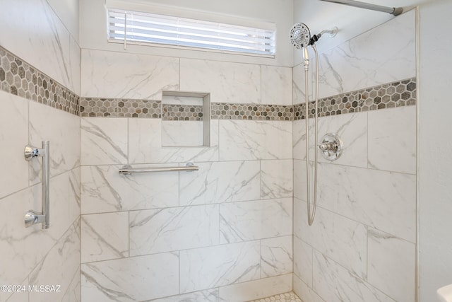 bathroom featuring a wealth of natural light and tiled shower