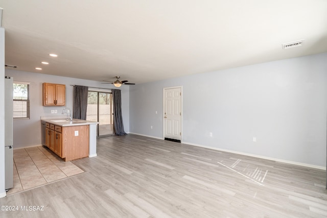 kitchen with light hardwood / wood-style floors, sink, and ceiling fan