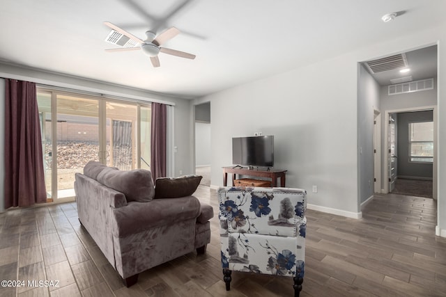 living room with dark wood-type flooring and ceiling fan