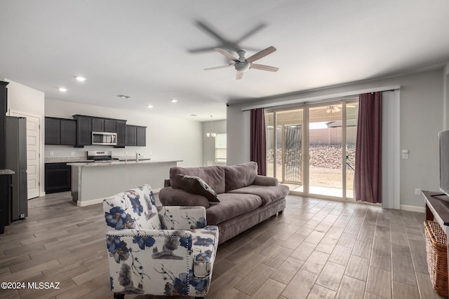 living room featuring sink, ceiling fan, and dark hardwood / wood-style flooring