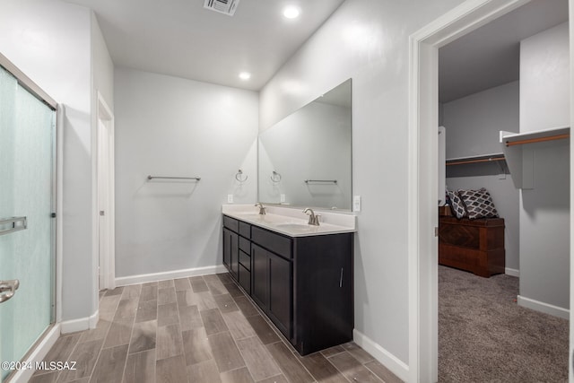 bathroom with vanity, hardwood / wood-style floors, and a shower with shower door