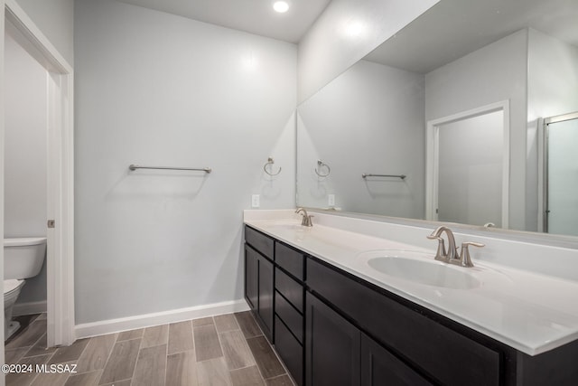 bathroom featuring vanity, toilet, and hardwood / wood-style flooring