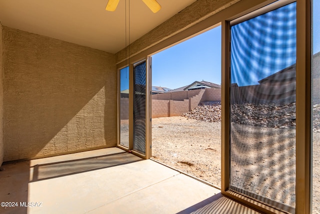 unfurnished sunroom with ceiling fan