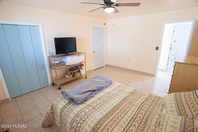 bedroom featuring light tile patterned floors, washer / dryer, and ceiling fan