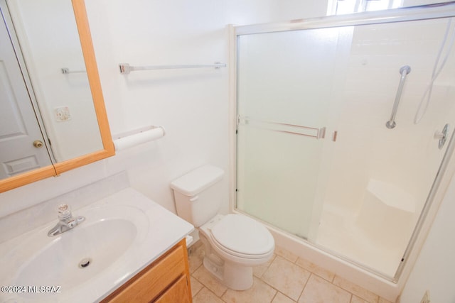 bathroom featuring vanity, tile patterned floors, toilet, and walk in shower