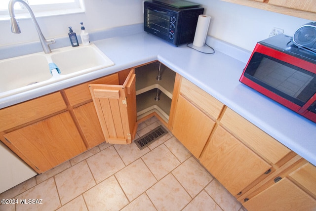 kitchen featuring light tile patterned flooring, sink, and built in desk