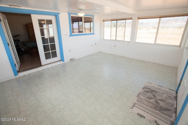 unfurnished sunroom featuring ceiling fan