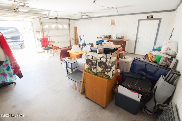 garage with a garage door opener and wooden walls