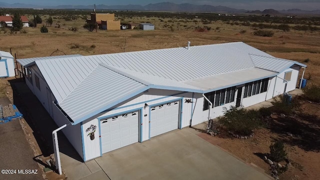 view of front facade featuring a garage, a mountain view, and a sunroom