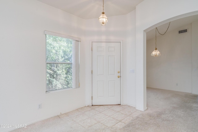 foyer featuring light carpet, visible vents, and light tile patterned flooring