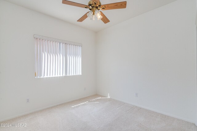 carpeted spare room featuring ceiling fan