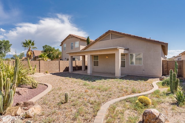 back of property with a patio area, stucco siding, and a fenced backyard