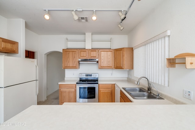 kitchen featuring visible vents, under cabinet range hood, a sink, white appliances, and arched walkways