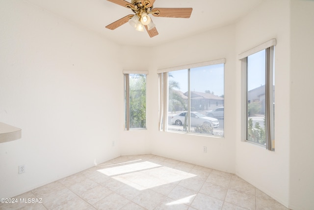 tiled empty room featuring ceiling fan