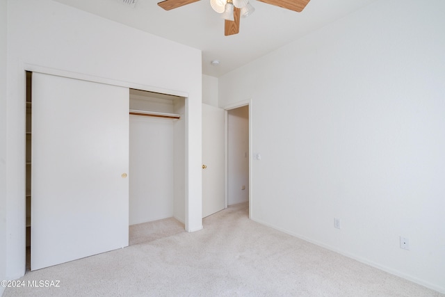 unfurnished bedroom featuring a closet, light colored carpet, and ceiling fan