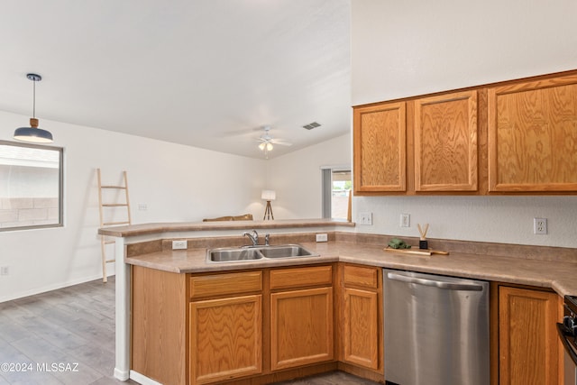 kitchen featuring kitchen peninsula, light wood-type flooring, dishwasher, decorative light fixtures, and sink