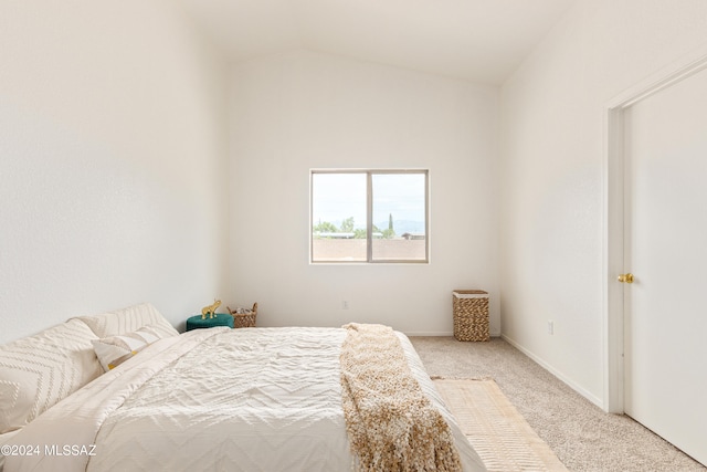 bedroom featuring light carpet and vaulted ceiling