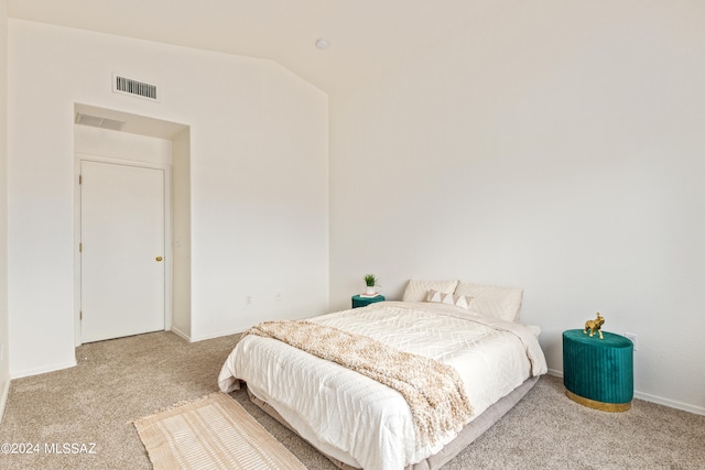 bedroom with lofted ceiling and light colored carpet