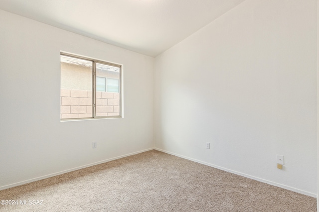 unfurnished room featuring lofted ceiling and carpet floors