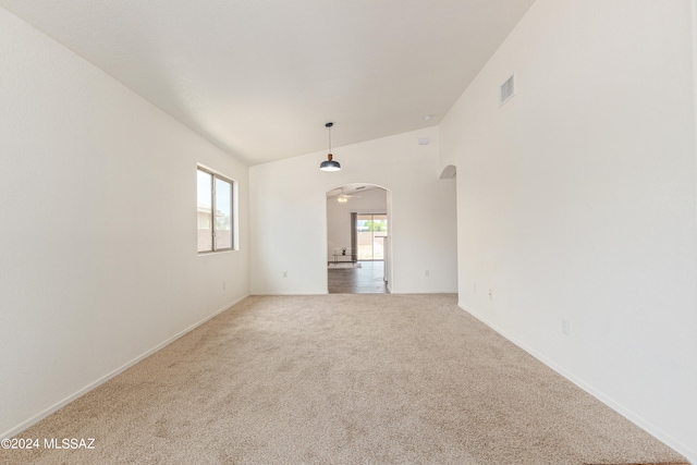 empty room featuring carpet flooring and vaulted ceiling