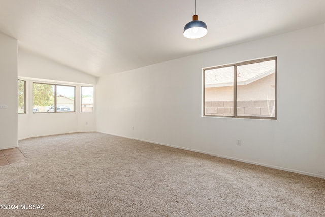 carpeted spare room with lofted ceiling