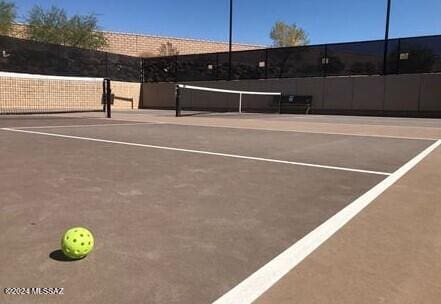 view of tennis court featuring fence and community basketball court