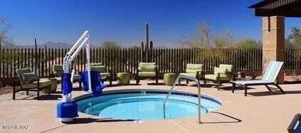 view of swimming pool with a hot tub, a patio, and fence