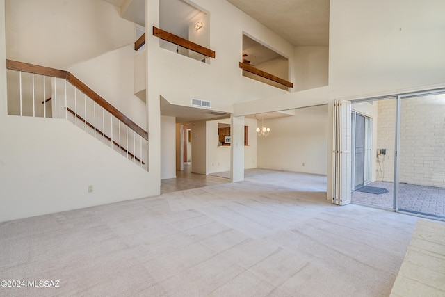 interior space featuring high vaulted ceiling, an inviting chandelier, and light colored carpet