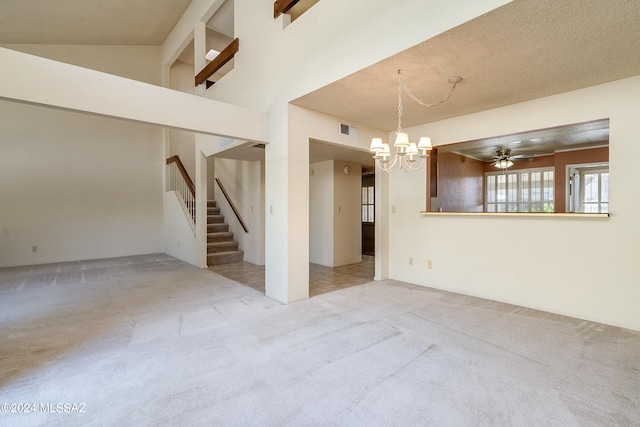 carpeted empty room featuring high vaulted ceiling, a textured ceiling, and ceiling fan with notable chandelier
