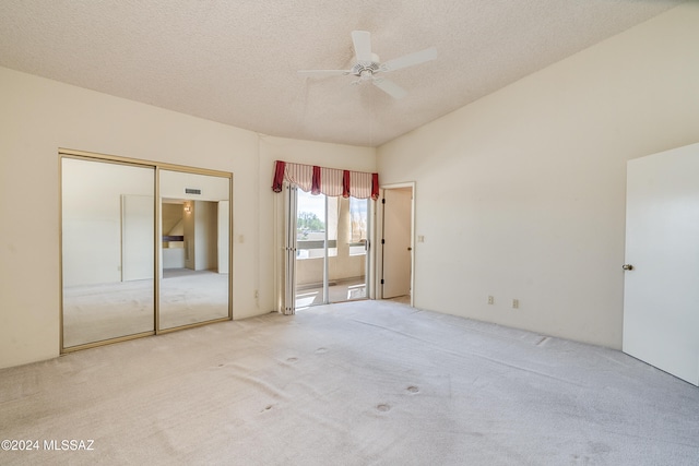 unfurnished bedroom with light carpet, a textured ceiling, a closet, and ceiling fan