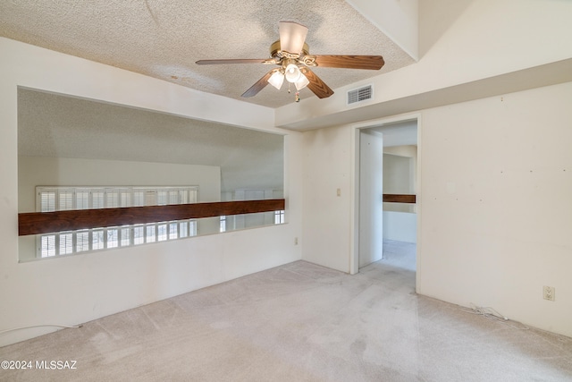 carpeted empty room featuring a textured ceiling and ceiling fan