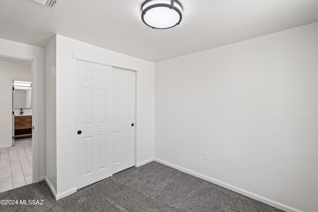 unfurnished bedroom featuring carpet and a closet