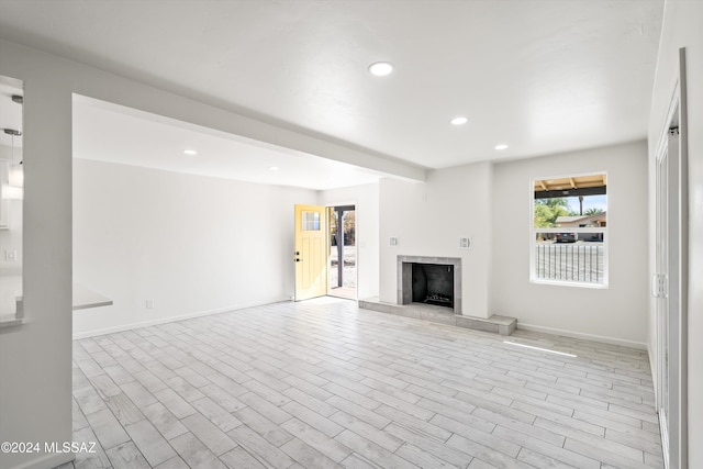 unfurnished living room with a fireplace and light hardwood / wood-style floors