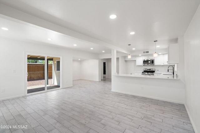 unfurnished living room with sink and light hardwood / wood-style flooring