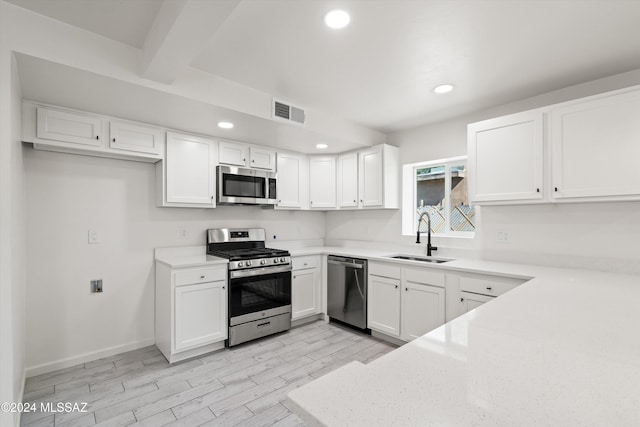 kitchen featuring sink, white cabinetry, stainless steel appliances, and light wood-type flooring