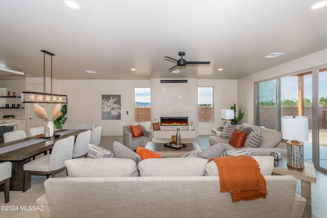 tiled living room with a fireplace and ceiling fan