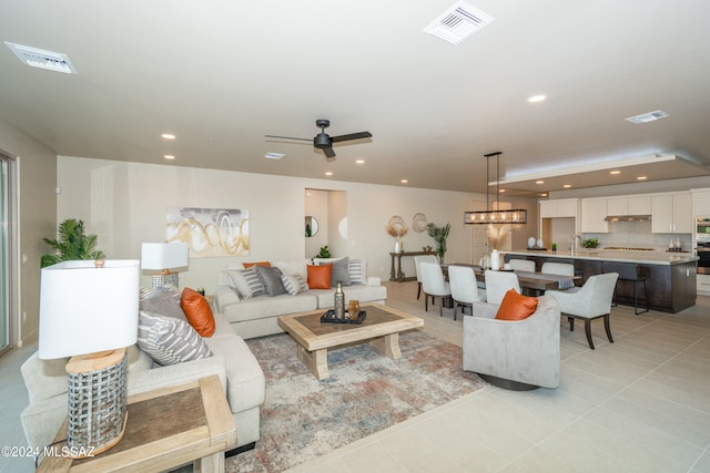 tiled living room featuring sink and ceiling fan