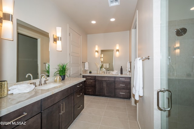 bathroom featuring vanity, a shower with shower door, and tile patterned flooring