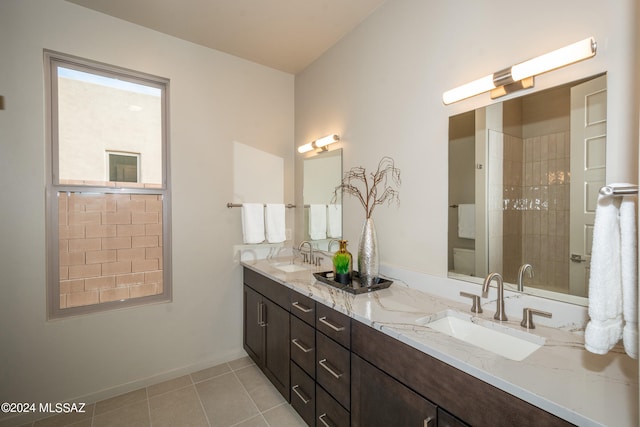 bathroom with vanity, a tile shower, and tile patterned floors