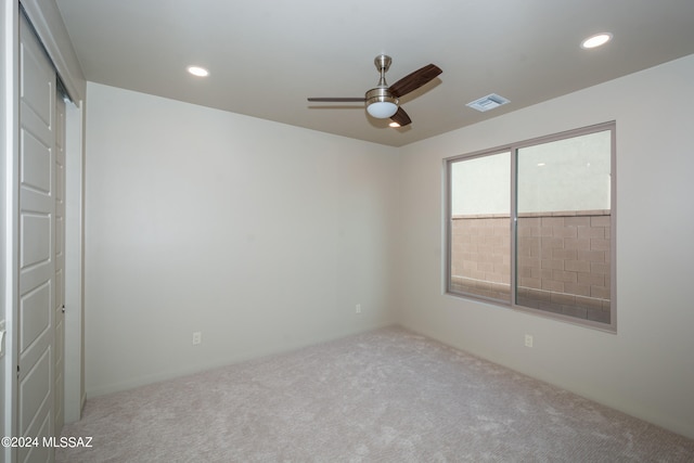 carpeted spare room with ceiling fan