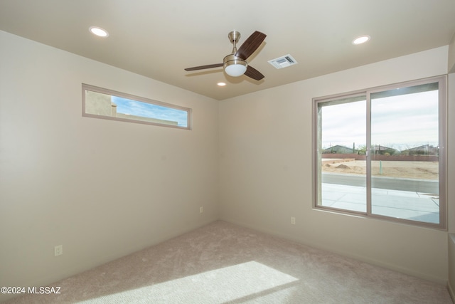 empty room featuring light carpet, a healthy amount of sunlight, and ceiling fan