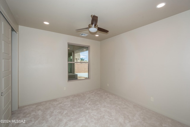 carpeted spare room featuring ceiling fan