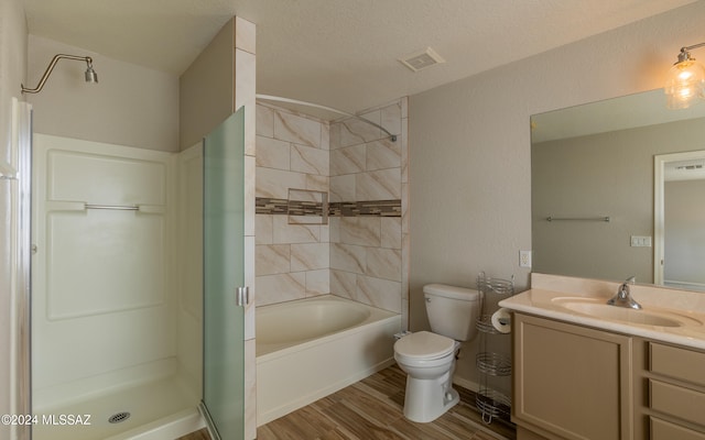 full bathroom featuring toilet, separate shower and tub, hardwood / wood-style floors, vanity, and a textured ceiling