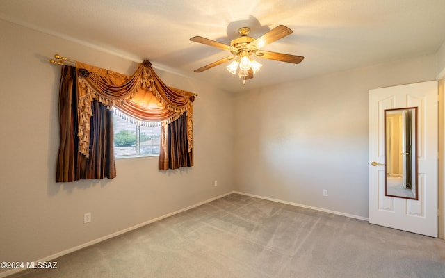 carpeted spare room featuring ceiling fan