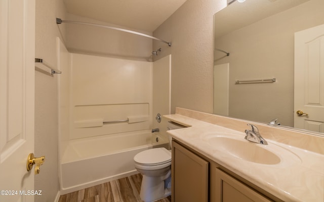 full bathroom featuring vanity, washtub / shower combination, hardwood / wood-style flooring, and toilet