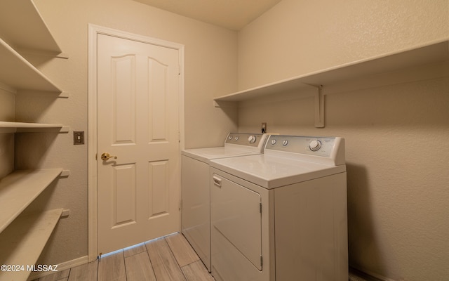 laundry area with light wood-type flooring and separate washer and dryer