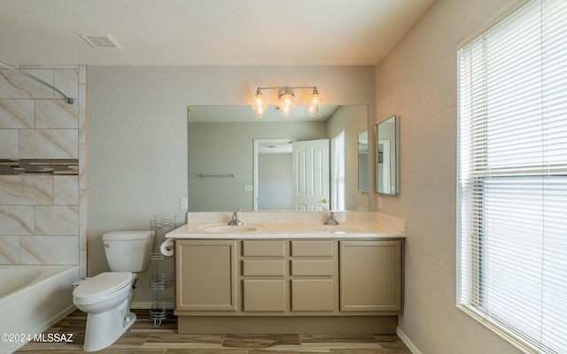 full bathroom featuring vanity, toilet, hardwood / wood-style flooring, and tiled shower / bath