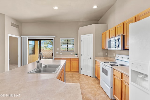 kitchen with white appliances, light tile patterned flooring, light brown cabinetry, and sink