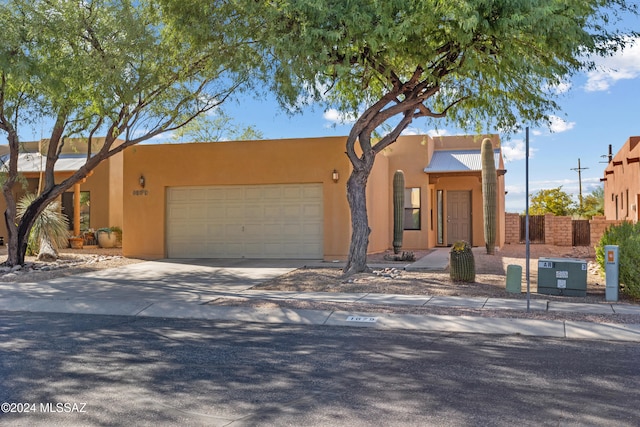 pueblo revival-style home with a garage