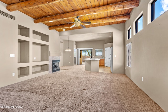 unfurnished living room with light carpet, wooden ceiling, a tile fireplace, and ceiling fan with notable chandelier